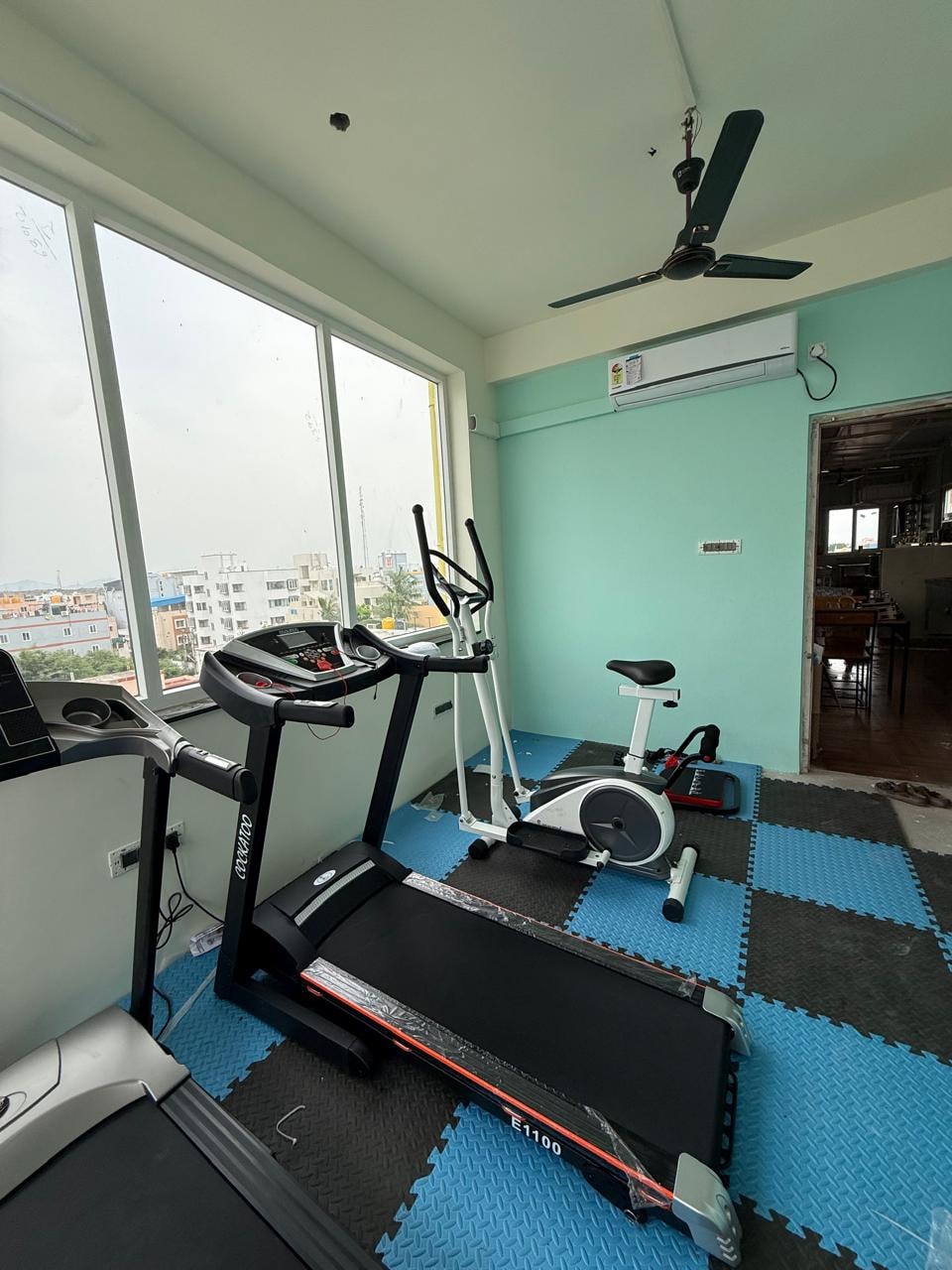 Oasis Living gym — full room view with cardio equipment